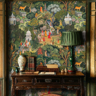 Indian garden paradise wallpaper with temples, deer, and lush botanicals in green tones, displayed in a traditional study with wooden desk and green lamp