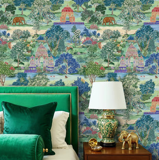 Indian garden wallpaper with elephants and ornate pavilions in green and blue, in a bedroom with gold elephant decor