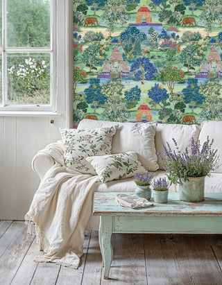 Indian scenic wallpaper featuring elephants amid green and blue trees, in a cottage living room with lavender pots and linen sofa