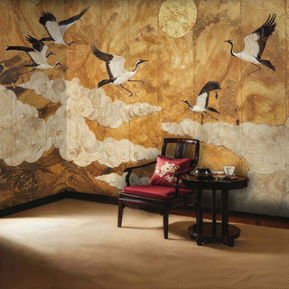 Japanese crane wall mural with moon and gold tones displayed in corner with red upholstered chair
