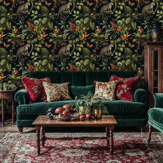 Jungle leopard wallpaper with exotic animals and botanicals, shown in elegant living room with green velvet sofa