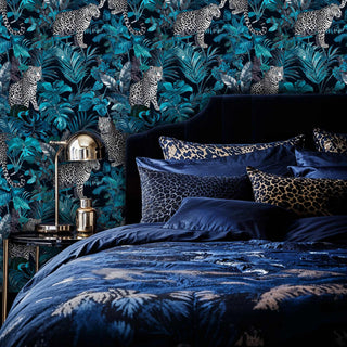 Jungle leopard wallpaper with spotted cats and tropical plants, shown in luxurious bedroom with navy bedding