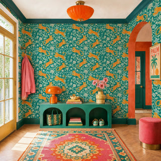 Leaping leopard wallpaper in teal and orange with scrolling florals in a colorful entryway with arched doorway