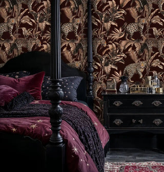leopard jungle wallpaper, sepia palms on burgundy, behind a black four poster bed