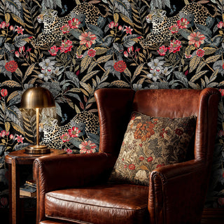 Leopard jungle wallpaper with coral blooms on black background, shown in luxurious bedroom with velvet bedding