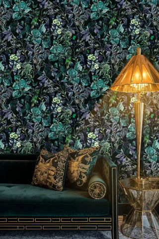 Lush botanical wallpaper with dark background and colorful leaves, displayed in opulent lounge with brass floor lamp and mirrored table