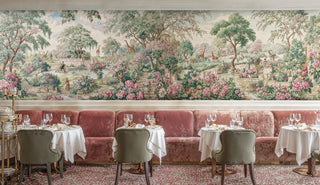 Lush rose garden wall mural with giraffes shown in an elegant restaurant with velvet banquette seating