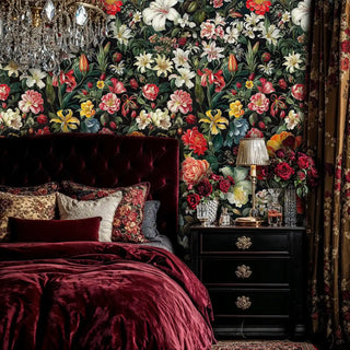 Luxurious floral wallpaper featuring colorful blooms on black background in dramatic bedroom with burgundy velvet headboard