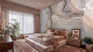 Luxurious marble geode wall mural with grey, pink tones and gold veining in elegant bedroom with earth-tone bedding