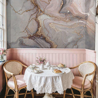 Luxurious marble wallpaper with gold accents in charming dining nook with pink wainscoting and tea service