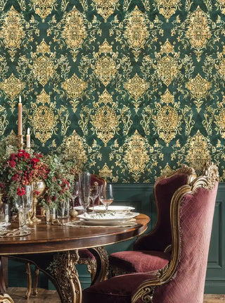 Luxury damask wallpaper in emerald and gold tones shown in elegant dining room with burgundy upholstered chairs