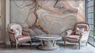 Marble geode wallpaper featuring flowing grey and gold patterns in classic sitting room with vintage pink armchairs
