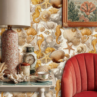 Marine life wallpaper featuring golden shells and seahorses in eclectic room with coral chair