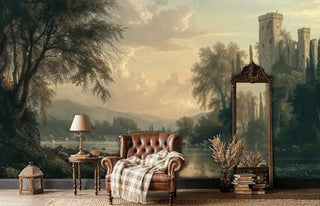 Medieval landscape wall mural featuring misty castle and golden light, shown with leather armchair and mirror