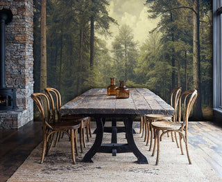 Misty Forest Path Wall Mural with tall trees in vintage green and brown, shown in a rustic dining room with a stone fireplace.