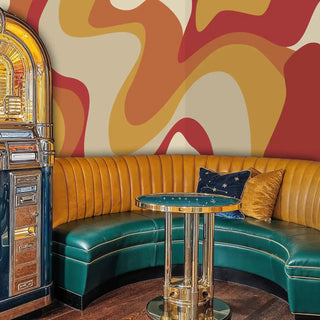 Modern abstract wallpaper featuring curved forms in vintage diner booth with teal leather seating