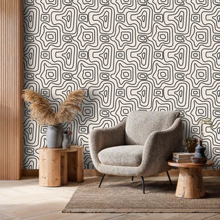 Modern geometric wallpaper featuring flowing patterns in living room with grey upholstered chair
