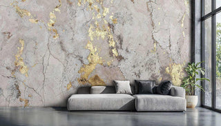 Modern industrial wall mural with gold leaf accents in a loft living area with a grey sectional sofa and large window.