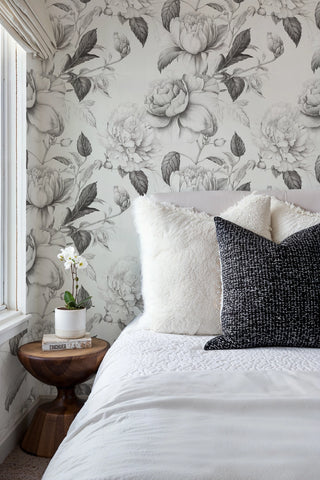Monochrome floral wallpaper with detailed roses in grey tones, shown in elegant bedroom with wooden nightstand