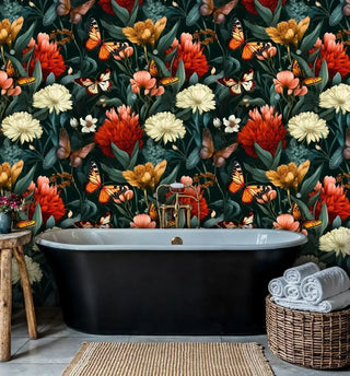 Moody floral and butterfly wallpaper creating a dramatic accent wall in a modern bathroom behind a black freestanding bathtub.