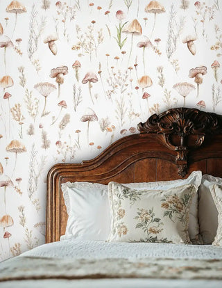 Mushroom botanical wallpaper with wild grasses pattern, shown behind ornate wooden bed headboard