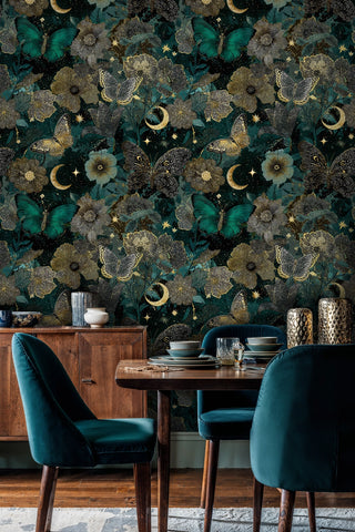 Mystical butterfly and moon wallpaper in teal and gold shown in a dining room with velvet chairs and set table