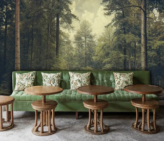 Mystical forest wall mural with dappled sunlight and ancient trees, shown in modern cafe with green banquette seating