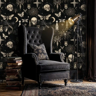 Mystical gothic wallpaper featuring skulls and moths in luxurious reading room with leather armchair