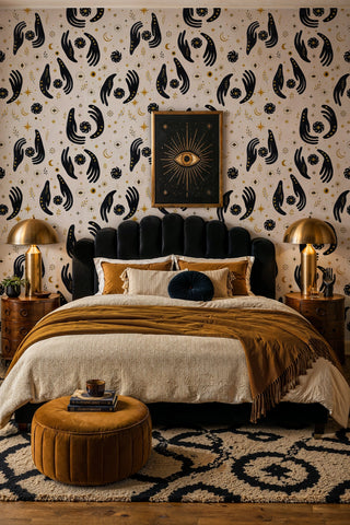 Mystical hands wallpaper with evil eyes and gold moons in a moody bedroom with velvet headboard and brass lamps