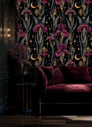 Mystical iris wallpaper with purple blooms and golden stars on black background, displayed in elegant bedroom setting
