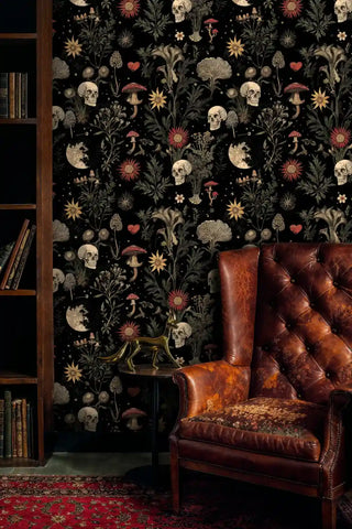 Mystical wallpaper featuring skulls and botanicals in a library setting with leather chair and bookshelves