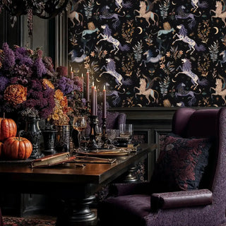 Mythical creatures wallpaper with winged lions in purple and beige on black, in a gothic dining room with a large floral centerpiece.