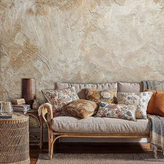 Natural plaster texture wallpaper in warm neutrals, featured in boho living room with floral pillows