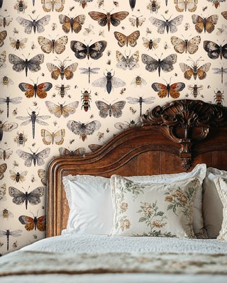 naturalist insect wallpaper showing butterflies and bees, styled in bedroom with ornate wooden headboard