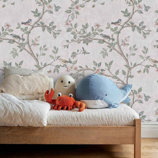 Nature wallpaper showing songbirds among blossoms in gentle colors, displayed in kids room with plush sea creature toys on bed