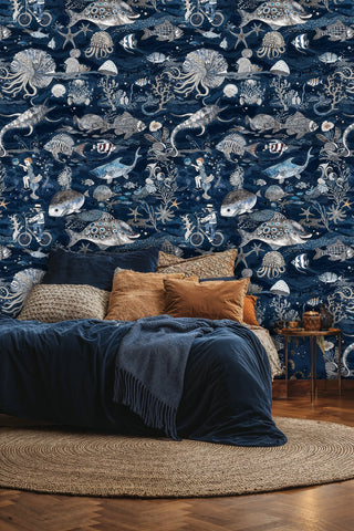 Nautical sea creature wallpaper with diving helmets, displayed in bedroom with orange accent pillows