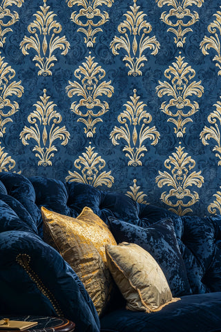 Navy and gold damask wallpaper with ornate flourishes, shown in luxury living room with velvet chesterfield sofa
