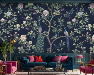 Navy floral peacock wallpaper in modern living room with pink velvet armchairs and brass fixtures