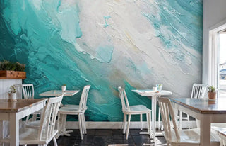 Ocean wave abstract wall mural with turquoise and white flowing paint, shown in modern cafe with wooden tables