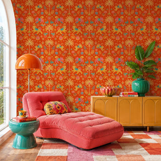 Orange folk art wallpaper with playful tigers and palm trees, in a vibrant living room with coral chaise lounge
