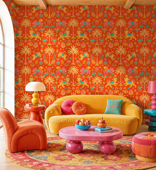 Orange tiger palm tree wallpaper with ornate details, in a maximalist living room with yellow curved sofa