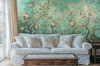 Oriental bird Wall Mural with flowering branches in teal and coral, displayed in living room with white linen sofa