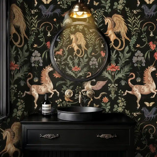 ornate unicorn and floral wallpaper in black and gold, shown behind a round mirror above a black sink in a luxe bathroom
