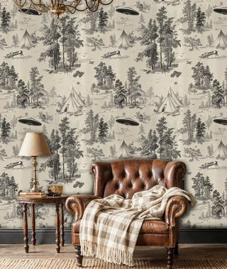 Otherworldly forest wall mural with UFO motifs in beige and black, featured in cozy reading chair corner
