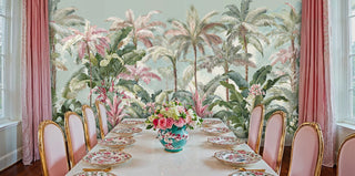 Palm tree wallpaper in soft green and pink tones displayed in formal dining room with pink upholstered chairs