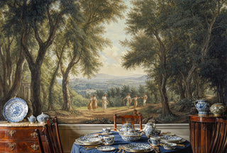 Pastoral landscape wall mural showing woodland scene with classical figures, featured in formal dining room with blue china