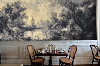 Peaceful river landscape wall mural in serene reading nook with armchair and woven ottoman