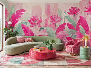 Pink lotus wall mural with tropical leaves in fuchsia and sage green, shown in a vibrant living room with curved green sofa