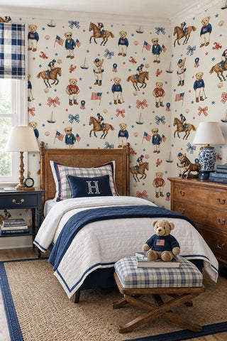 Preppy bear wallpaper with polo horses, sailboats, and stars in navy and red, in a kids bedroom with rattan bed frame