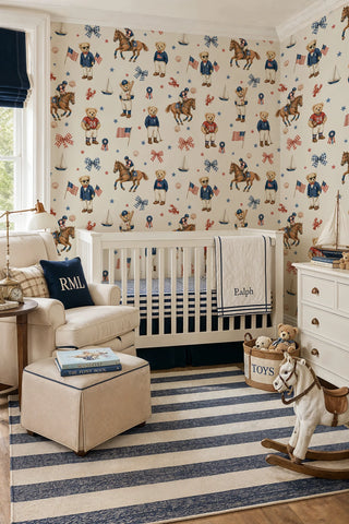 Preppy teddy bear wallpaper with sailboats, horses, and flags in navy and red on ivory, in a classic nursery with white crib